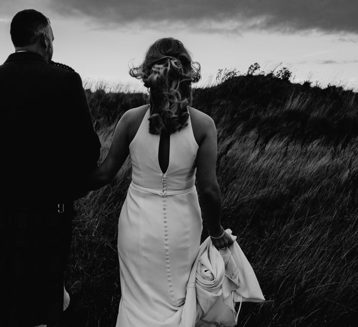 Bride in Anne Priscilla Signature Gown with Halterneck, Keyhole Back and Belt | Groom in Mackintosh Tartan Red and Black Kilt with Green Jacket and Waistcoat | Festoon Light Canopy and Indoor Trees for Humanist Wedding in St Andrews | Carla Blain Photography