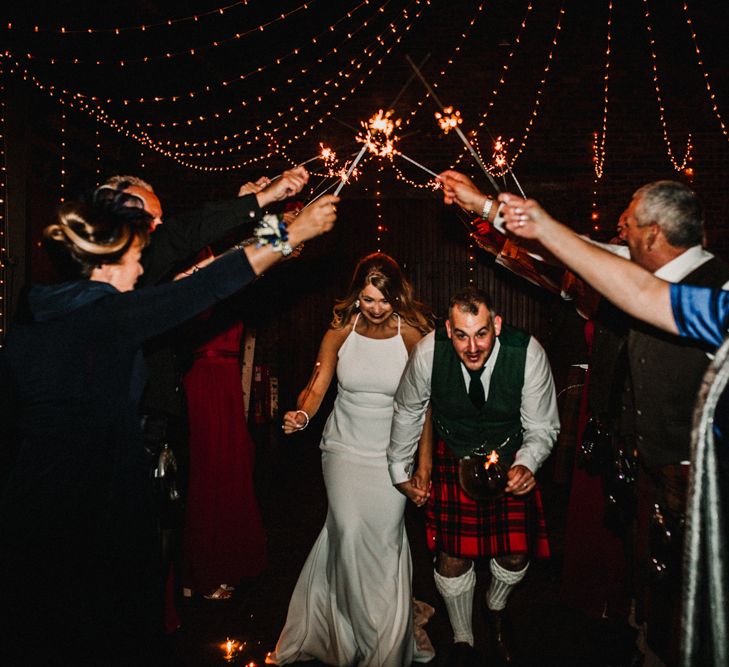 Bride in Anne Priscilla Signature Gown with Halterneck, Keyhole Back and Belt | Groom in Mackintosh Tartan Red and Black Kilt with Green Jacket and Waistcoat | Sparkler Send Off | Festoon Light Canopy and Indoor Trees for Humanist Wedding in St Andrews | Carla Blain Photography