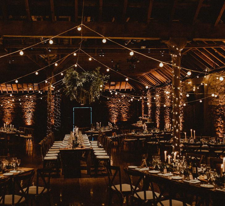 Wooden Banquet Tables | Foliage Table Runners | White Tapered Candles | Rosemary Sprig Place Settings | Foliage Hanging Decoration | Kinkell Byre Wedding Venue | Festoon Light Canopy and Indoor Trees for Humanist Wedding in St Andrews | Carla Blain Photography