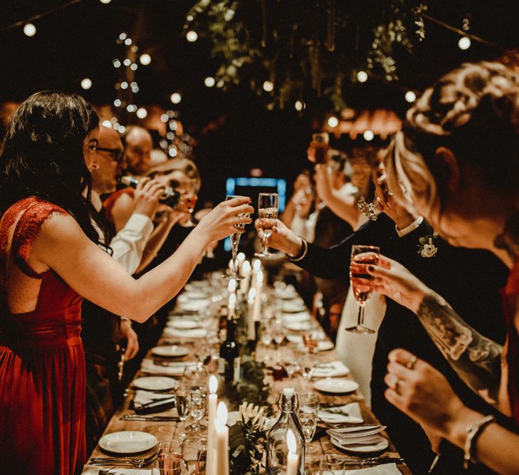 Bridesmaids in Maroon ASOS Dresses with Lace Cap Sleeves, Halterneck and Leg Split | Wooden Banquet Tables | Foliage Table Runners | White Tapered Candles | Kinkell Byre Wedding Venue | Festoon Light Canopy and Indoor Trees for Humanist Wedding in St Andrews | Carla Blain Photography