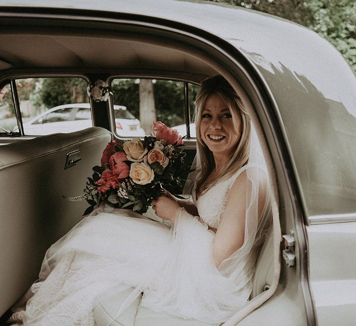 Bride in Vintage Wedding Car with Peony Wedding Bouquet in Lace Dress