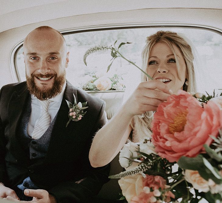 Bride and Groom in Wedding Car with Coral Peony Bouquet