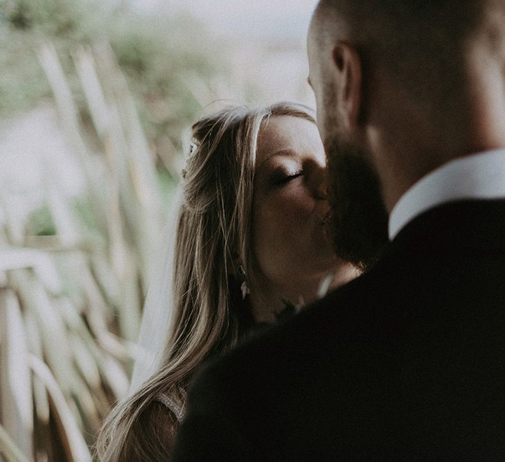 Bride and Groom Kiss on Beach After Ceremony