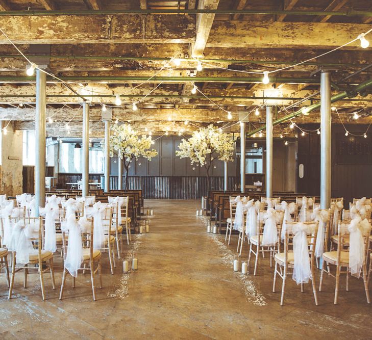 Ceremony Décor at Holmes Mill | Cherry Blossom Tree Altar | White Material Chair Sashes | Pillar Candles | Aisle Petals | Festoon Lights | Lace Bridal Cape Veil &amp; Fishtail Wedding Dress by Pronovias | On Love and Photography