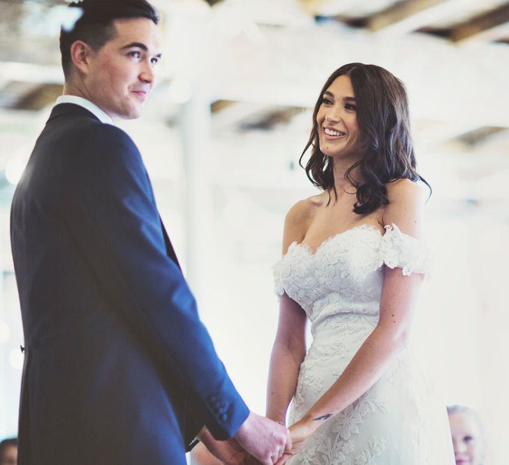 Wedding Ceremony | Bride in Embroidered Pronovias Wedding Dress with Off Shoulder Sleeves and Veil Cape | Groom in Navy Tails and Grey Waistcoat | Bride Wearing Hair Down | Lace Bridal Cape Veil &amp; Fishtail Wedding Dress by Pronovias | On Love and Photography