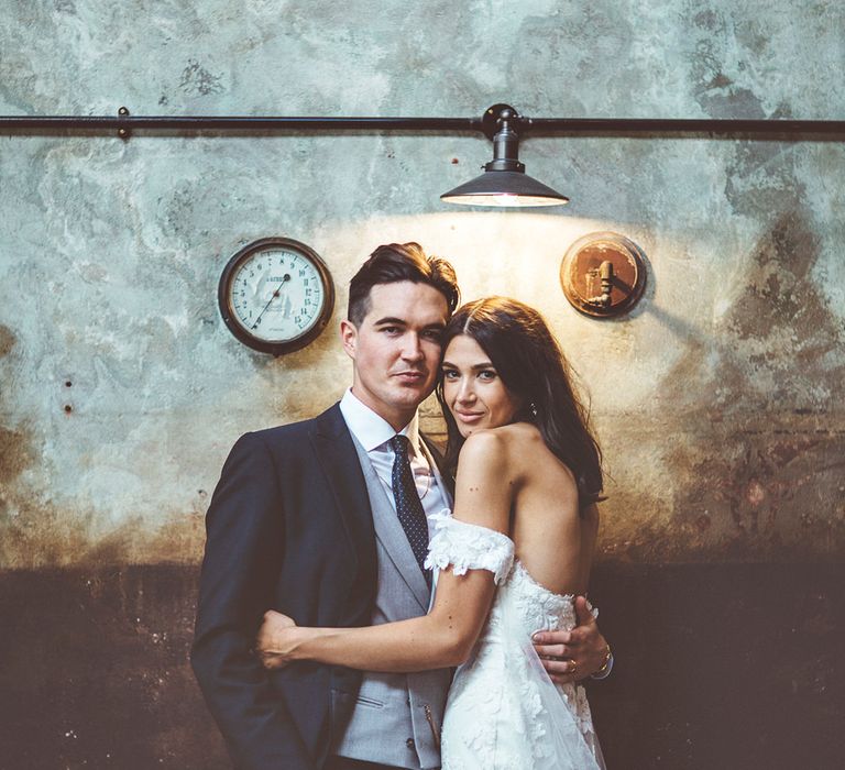 Bride in Fishtail Pronovias Wedding Dress with Off Shoulder Sleeves and Veil Cape | Groom in Navy Tails and Grey Waistcoat | Bride Wearing Hair Down | Lace Bridal Cape Veil &amp; Fishtail Wedding Dress by Pronovias | On Love and Photography