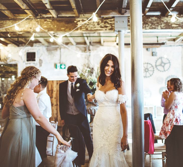 Bride in Fishtail Pronovias Wedding Dress with Off Shoulder Sleeves and Veil Cape | Groom in Navy Tails and Grey Waistcoat | Bride Wearing Hair Down | Festoon Lights | Lace Bridal Cape Veil &amp; Fishtail Wedding Dress by Pronovias | On Love and Photography