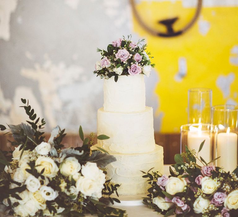 Three Tier Wedding Cake with Buttercream Icing | Bouquet of White Roses and Greenery | Bouquet of Dusky Purple Roses and Greenery | Pillar Candles | Lace Bridal Cape Veil &amp; Fishtail Wedding Dress by Pronovias | On Love and Photography