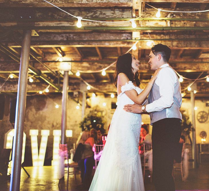 First Dance | Bride in Fishtail Pronovias Wedding Dress with Off Shoulder Sleeves and Veil Cape | Groom in Navy Tails and Grey Waistcoat | Bride Wearing Hair Down | Festoon Lights | Lace Bridal Cape Veil &amp; Fishtail Wedding Dress by Pronovias | On Love and Photography