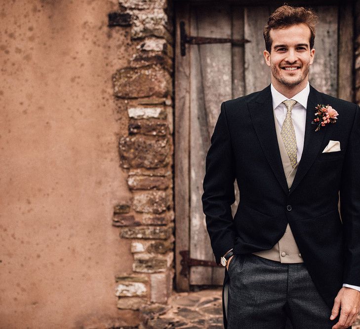 Groom in wedding suit with tails at Dewsall Court wedding