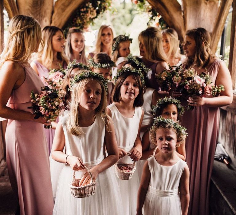 Bridesmaids and flower girls wait to enter church ceremony