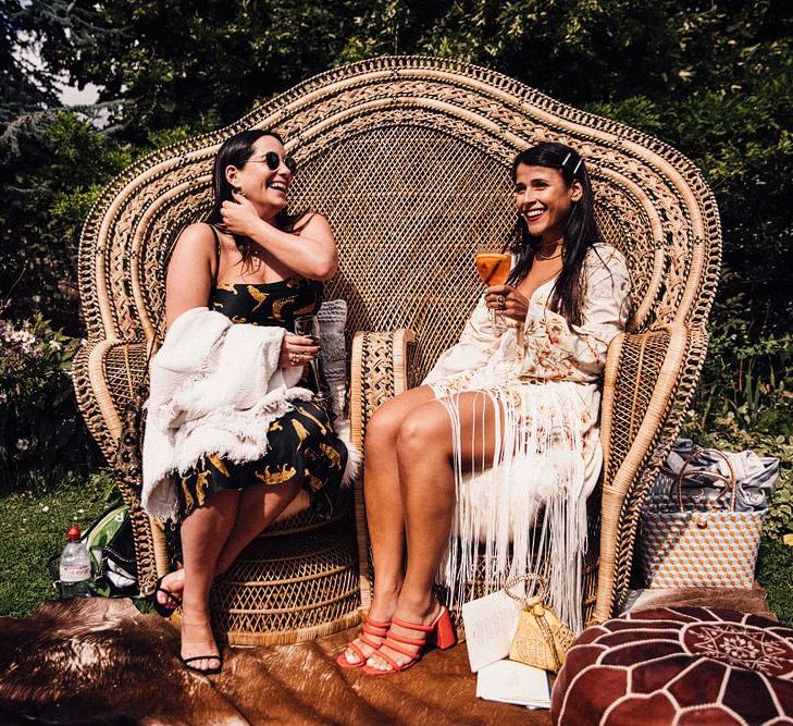 Large peacock chair at outdoor wedding drinks