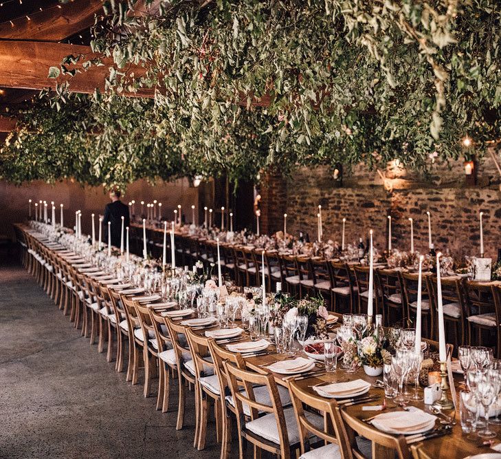 Rustic wedding breakfast decor with hanging foliage