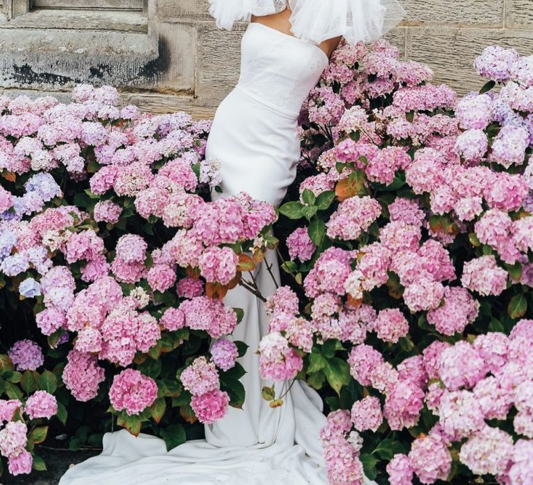 Bride standing in a hydrangea bush at Chiddingstone Castle