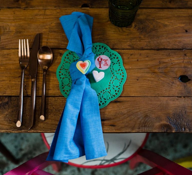 Place setting with green doily and blue napkin