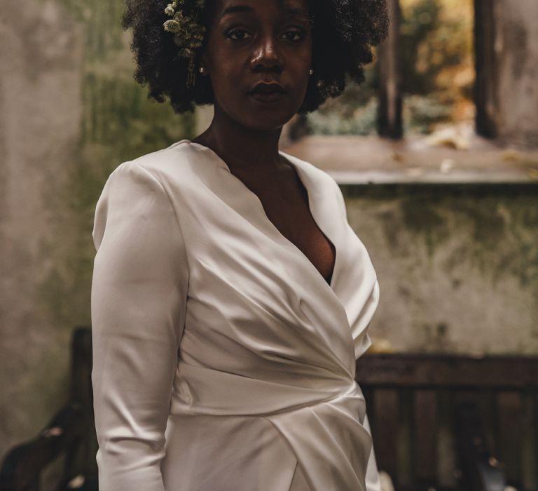 Black bride in satin wrap wedding dress with flowers in her hair