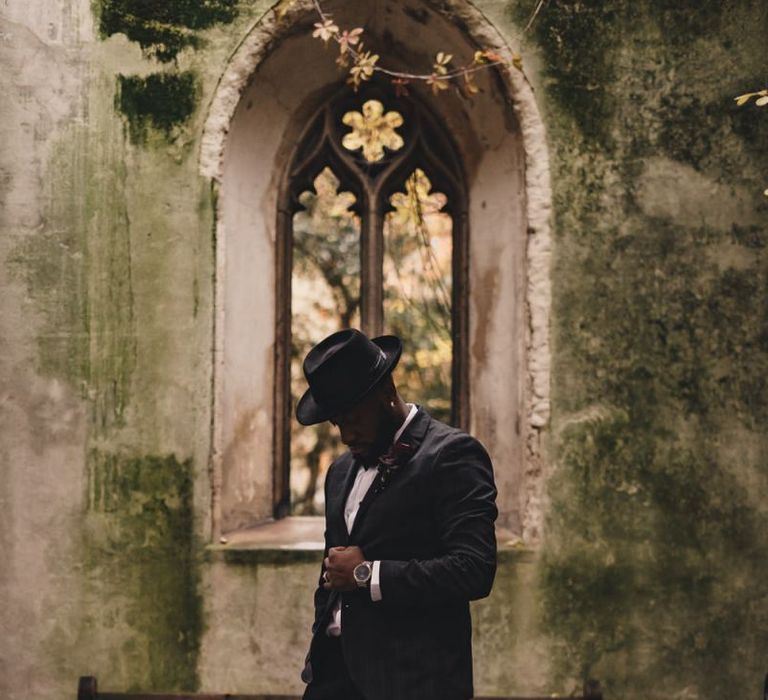 Stylish groom in tuxedo and hat at St Dunstan in the East