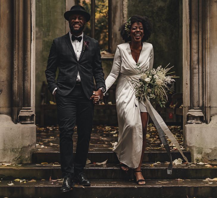 Black bride in high street wedding dress and groom in hat and bow tie for London wedding