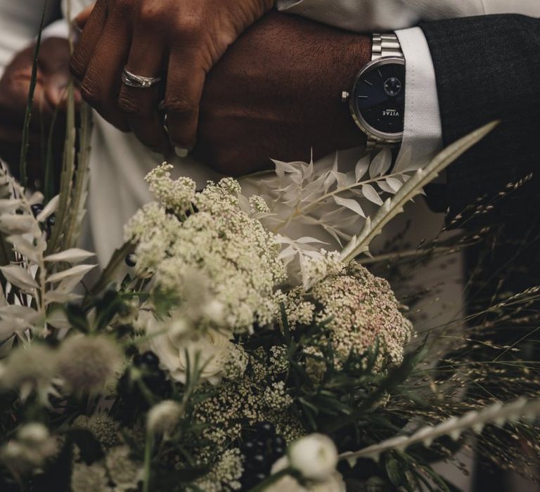 Bride and groom embracing showing off their Vitae watches