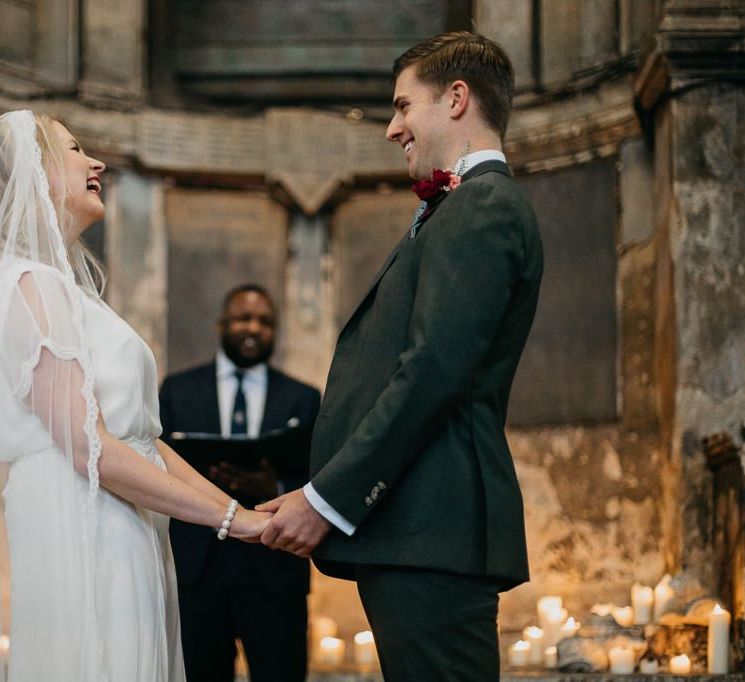 Bride and  groom say 'I do' at London celebration with candle light backdrop