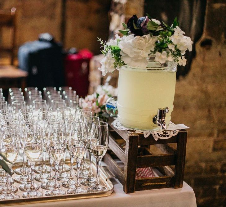 Drinks table at colourful and fun reception in London with floral and pine cone wedding decor