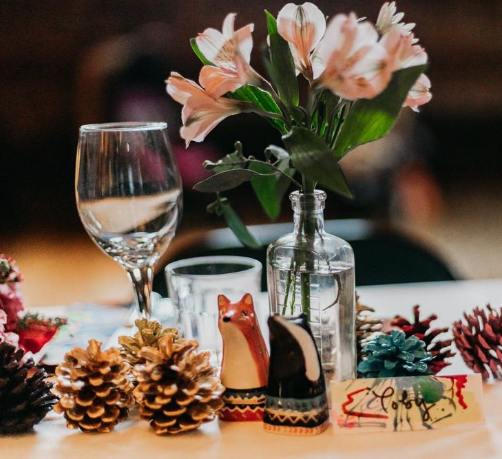 Centrepieces with pine cone wedding decor bright floral arrangements and ceramic animals