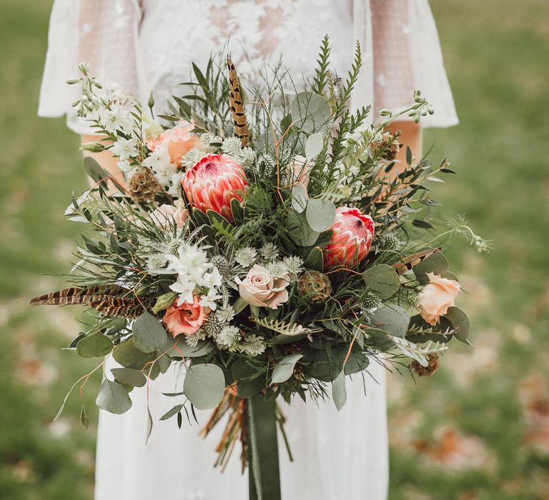 Foliage, Coral Flowers &amp; Pheasant Feather Bouquet | Country Boho Inspiration in the Woodlands of Happy Valley Norfolk | Cara Zagni Photography