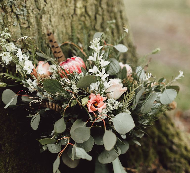 Foliage, Coral Flowers &amp; Pheasant Feather Bouquet with Proteas | Country Boho Inspiration in the Woodlands of Happy Valley Norfolk | Cara Zagni Photography