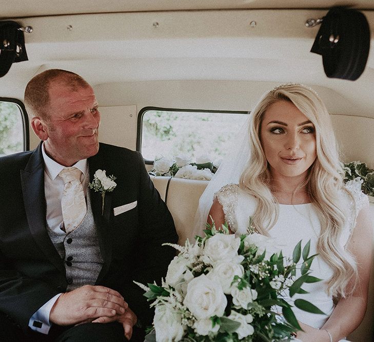 Father of the Bride and Bride in St Patrick Wedding Dress Sitting in Vintage Wedding Car