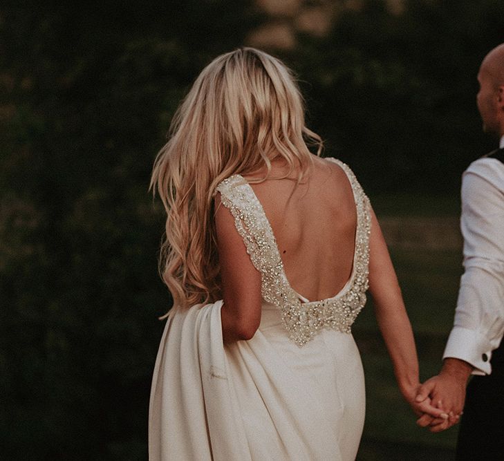 Bride in St Patrick Wedding Dress with Jewel Low Back Detail Walking  With Her Groom