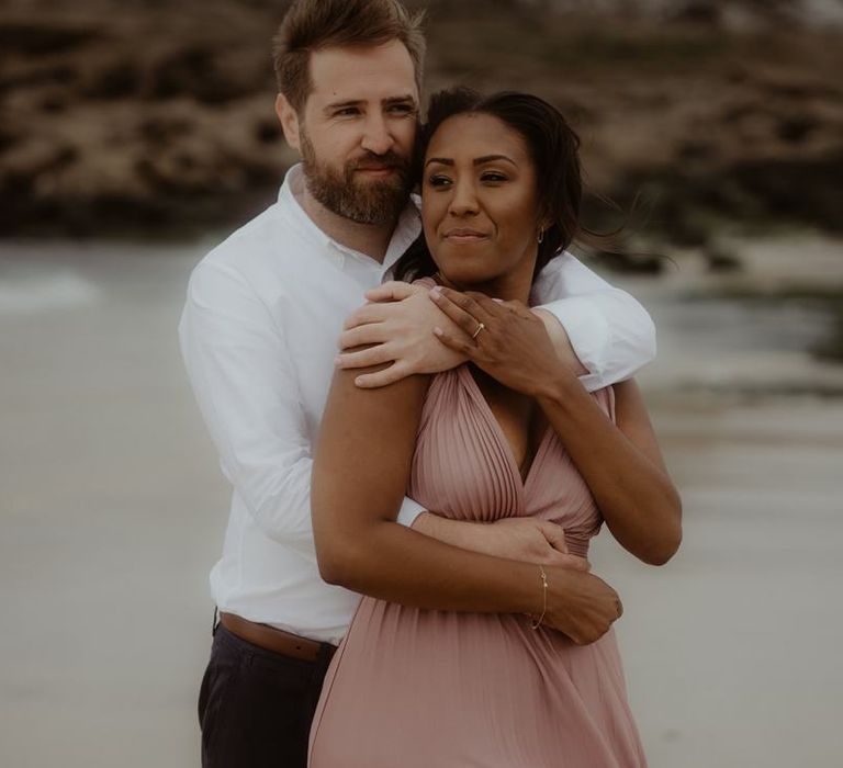 Bride and groom embracing on the beach