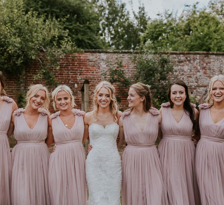 Pink bridesmaid dresses next to Enzoani wedding dress