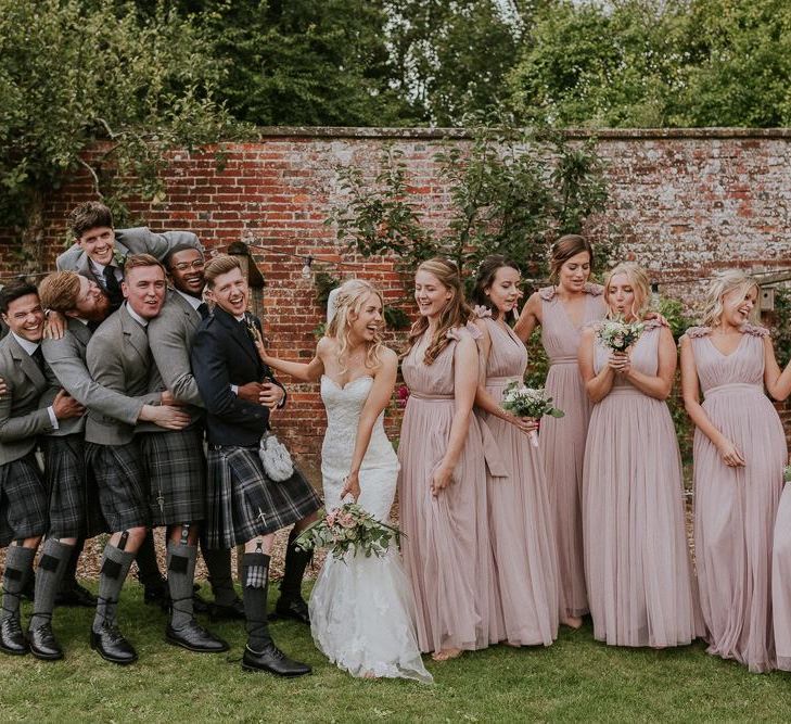 Pink bridesmaid dresses next to bride in Enzoani wedding dress