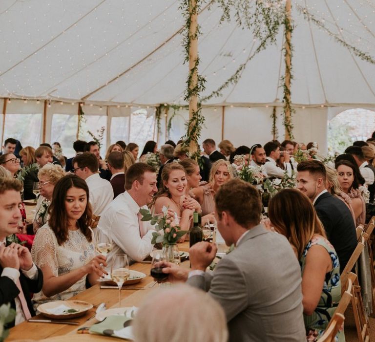 Guests enjoy dinner in marquee wedding