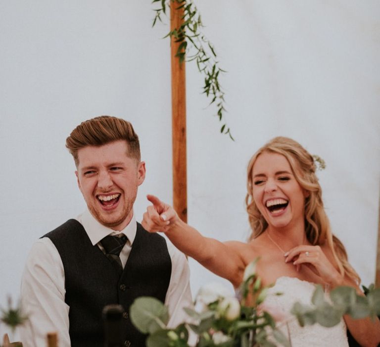 Bride and groom enjoy wedding speeches