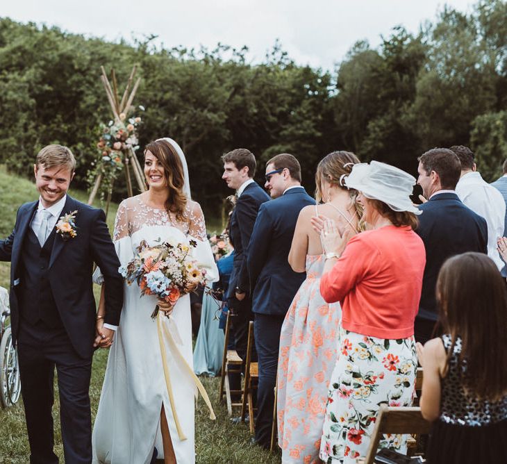 Bride in Rime Arodaky Wedding Dress and Groom is Reiss Suit at Outdoor Wedding Ceremony