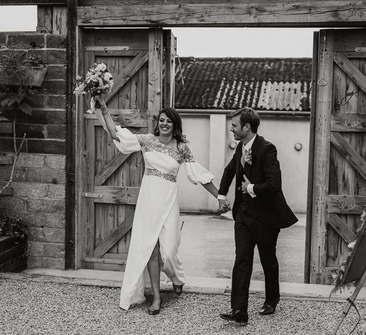 Bride in Rime Arodaky Wedding Dress and Groom is Reiss Suit Entering the Glasshouse Wedding Reception