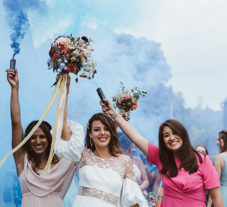 Bride in Rime Arodaky Wedding Dress and Friends Celebrating with Coloured Smoke Flares