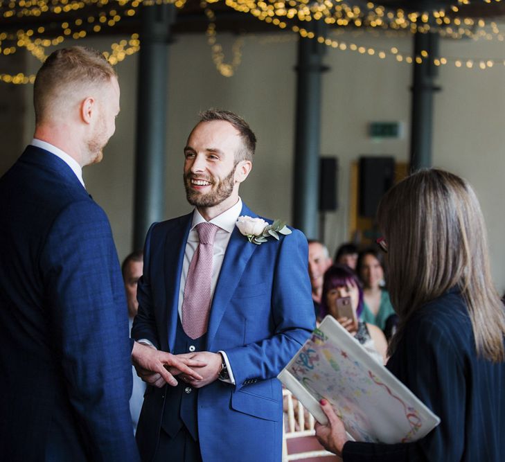 Wedding Ceremony with Two Grooms in Navy Blue Suits Exchanging Vows