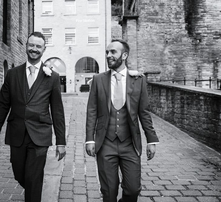 Two Groom's in Navy Suits Walking Down Cobbled Streets