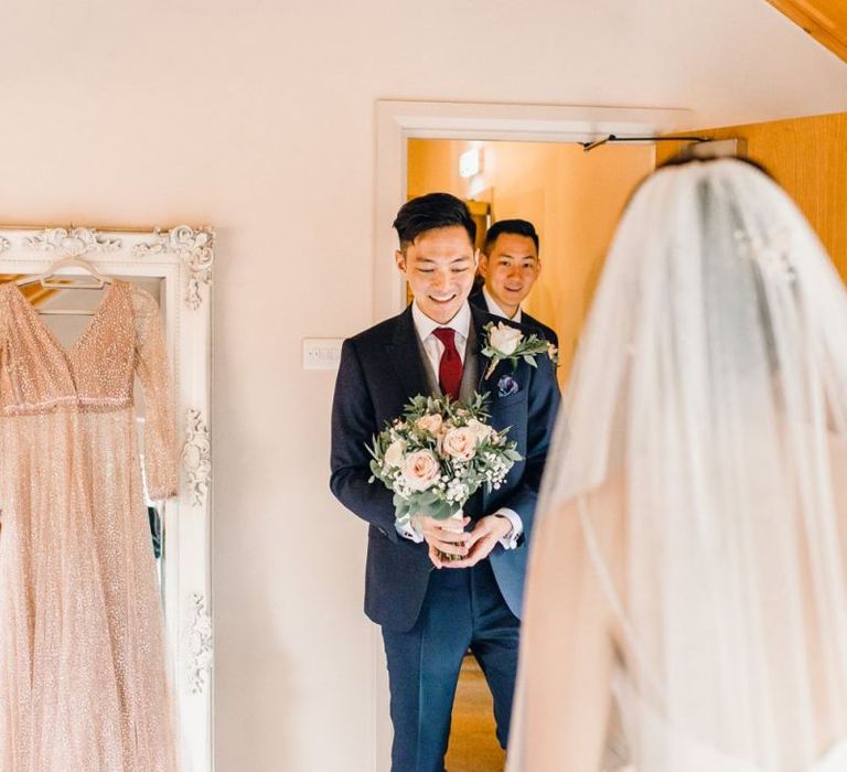 Groom seeing the bride before the ceremony with dusky pink rose bouquet