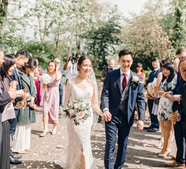 Bride and groom confetti shot with dusky pink rose wedding bouquet