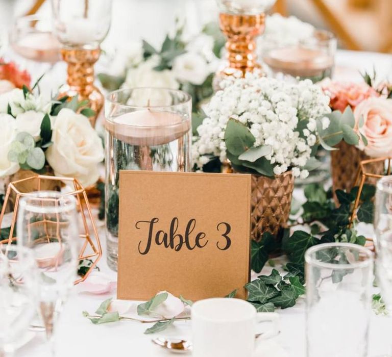 Table number signs with rose gold detailing and gypsophila bouquets