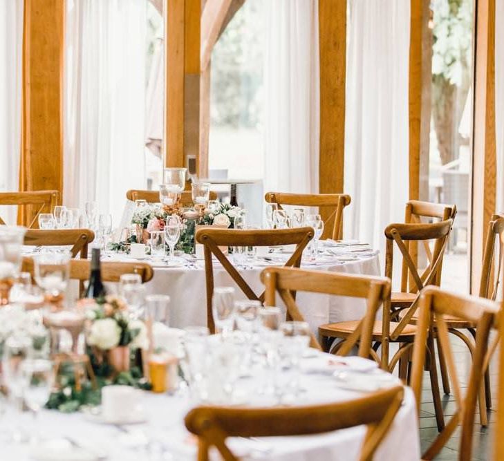 Wedding table styling for rustic reception with wooden detailing and gypsophila bouquets