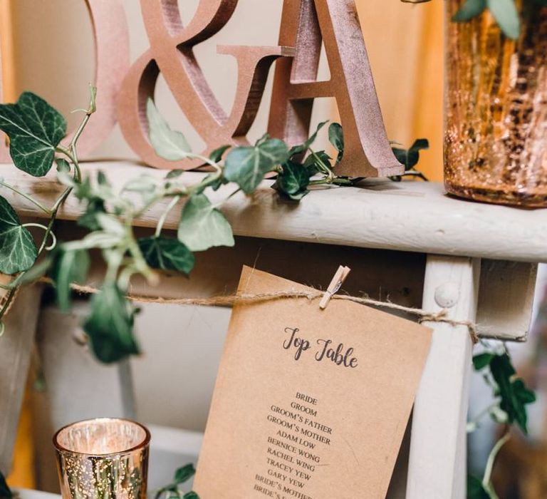 Rustic styled table plan with pegs and rose gold detailing