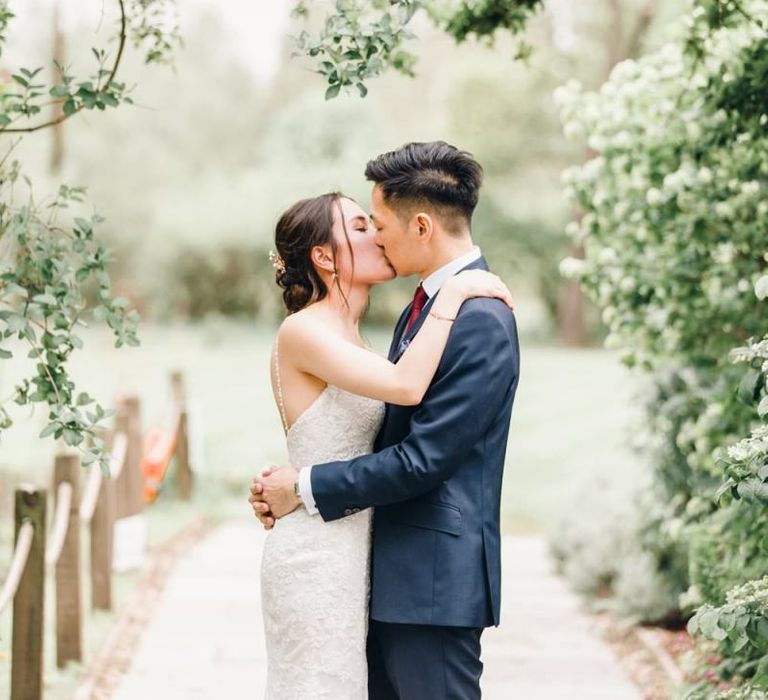 Bride and groom steal a moment with gypsophila archway