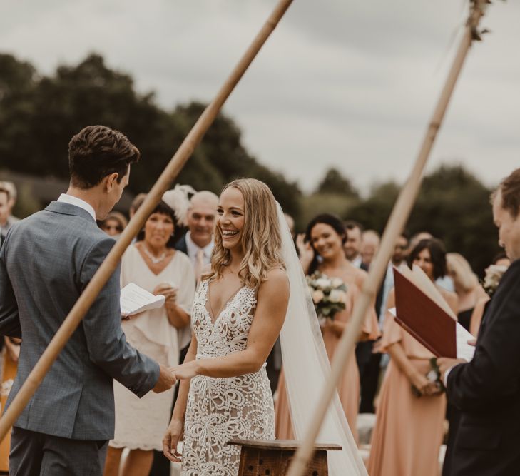 Bride in Sasha Dress by Made With Love with Crochet Finish, Fishtail Train, V-Neck and Plunging Back | Groom in Light Blue Two-Piece Suit by Hugo Boss | Bridesmaids in Mismatched Peach Rewritten Dresses, Tops and Skirts | Yurt Wedding with Outdoor Naked Tipi Ceremony, Glitter Station &amp; Peach Rewritten Bridesmaid Dresses | Nesta Lloyd Photography