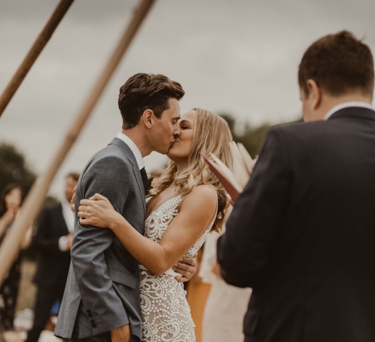 Bride in Sasha Dress by Made With Love with Crochet Finish, Fishtail Train, V-Neck and Plunging Back | Groom in Light Blue Two-Piece Suit by Hugo Boss | Yurt Wedding with Outdoor Naked Tipi Ceremony, Glitter Station &amp; Peach Rewritten Bridesmaid Dresses | Nesta Lloyd Photography