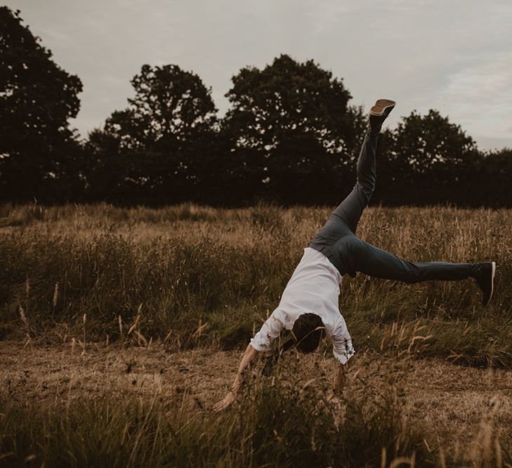 Groom in Light Blue Two-Piece Suit by Hugo Boss | Groom Doing Cartwheel | Yurt Wedding with Outdoor Naked Tipi Ceremony, Glitter Station &amp; Peach Rewritten Bridesmaid Dresses | Nesta Lloyd Photography