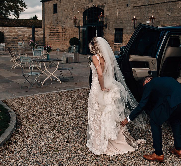 Bride in Lace wedding dress getting out of the wedding car